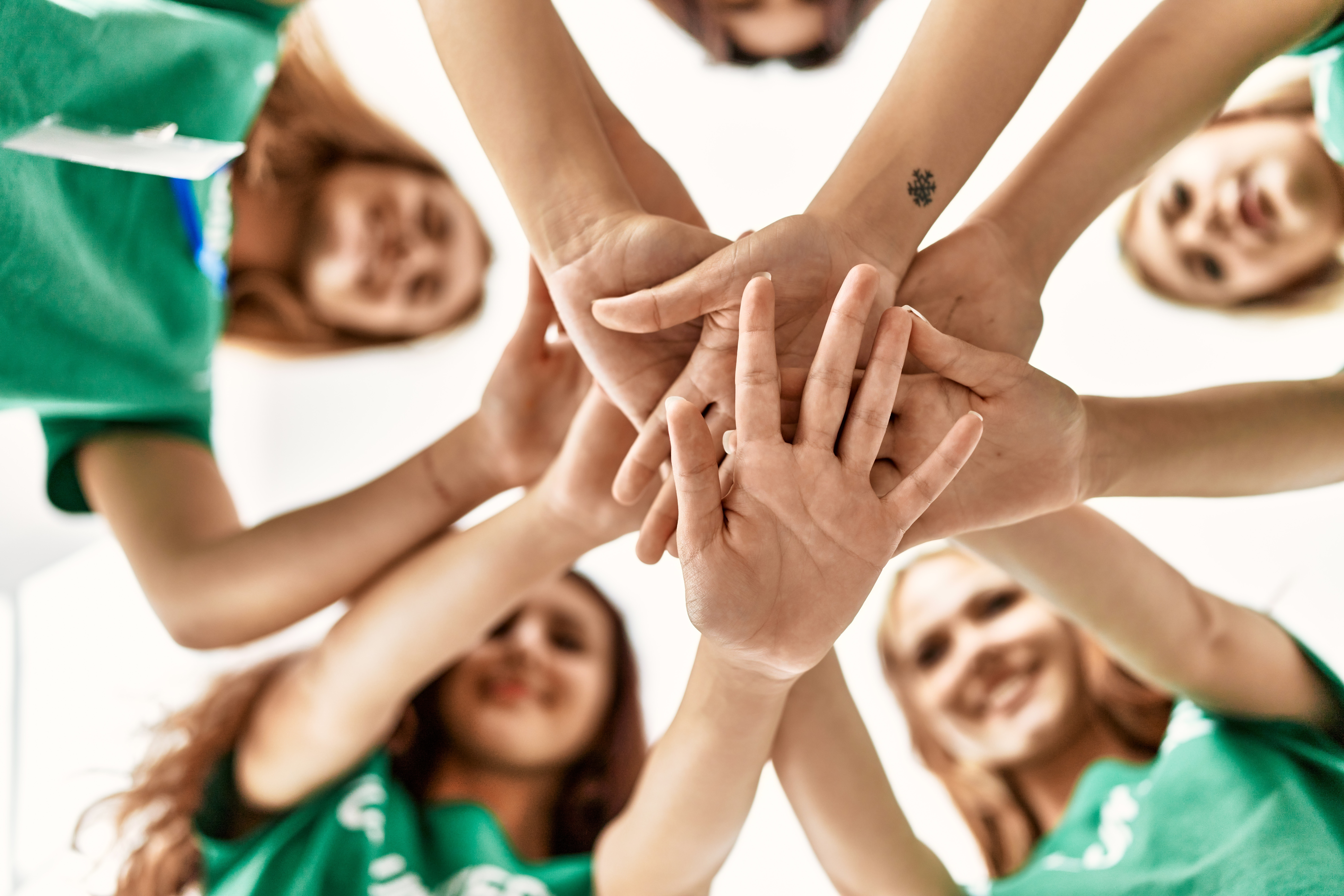 Group of young volunteers woman smiling happy with hands together at charity center